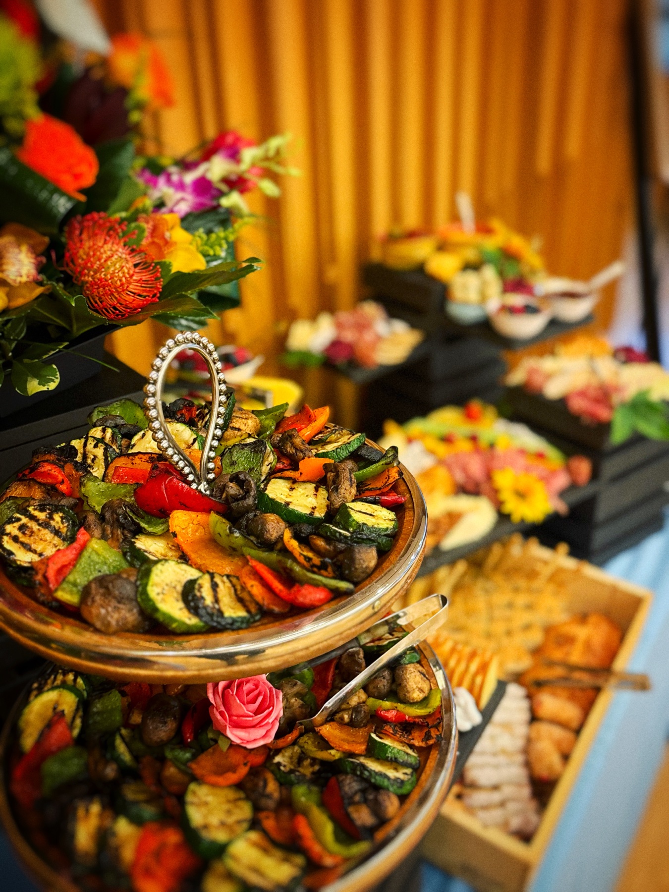 Tiered display of grilled vegetables with flowers