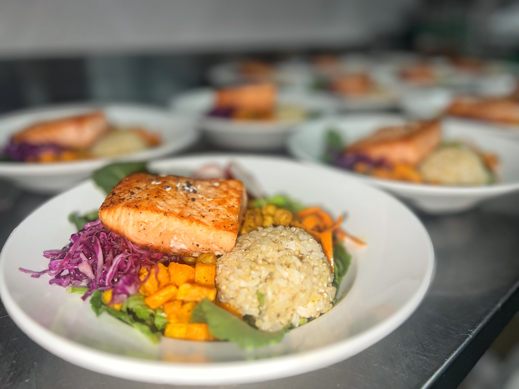 Chef-prepared salmon with grains and colorful vegetables