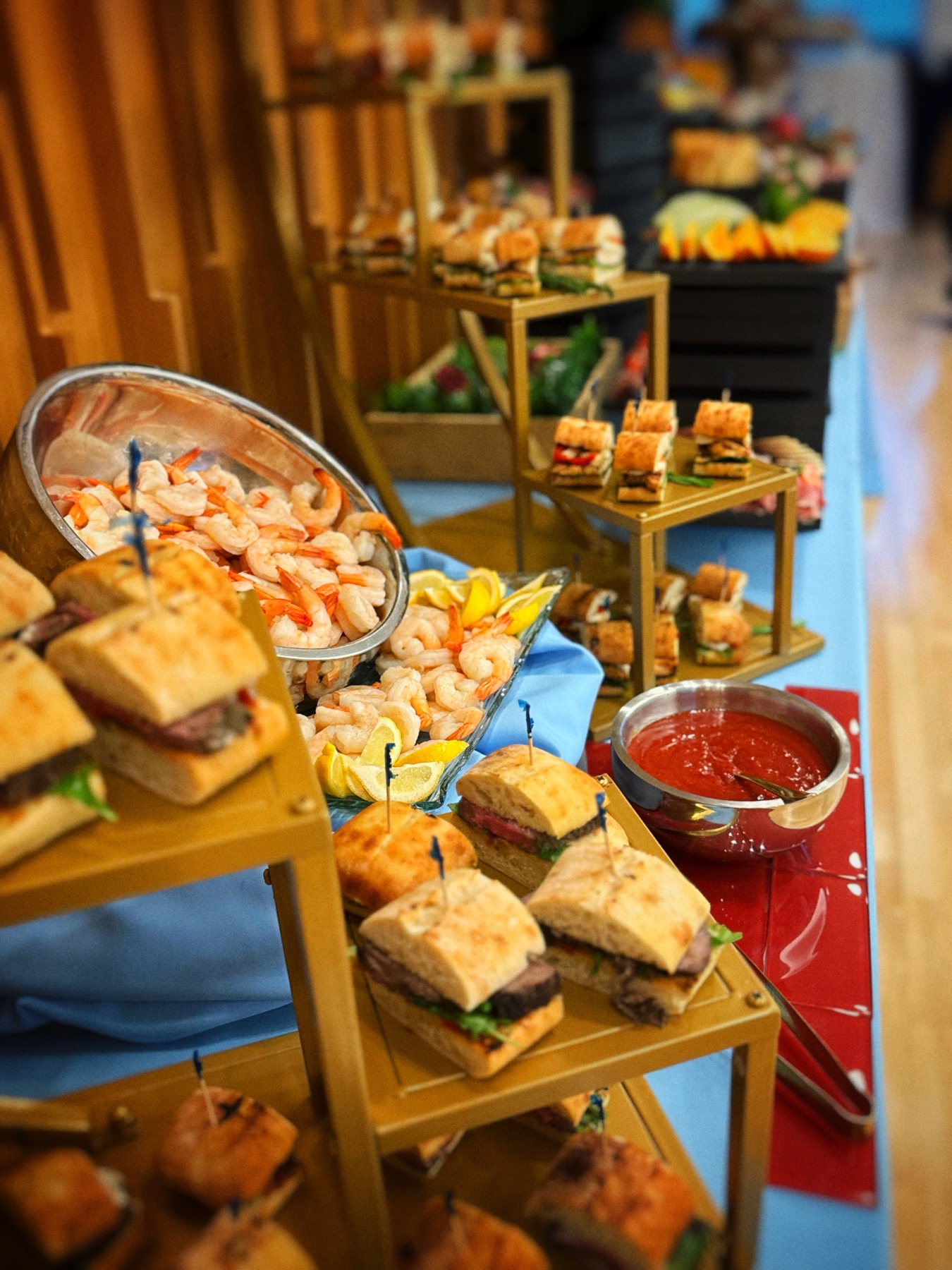 Shrimp platters and small sandwiches arranged for a gathering